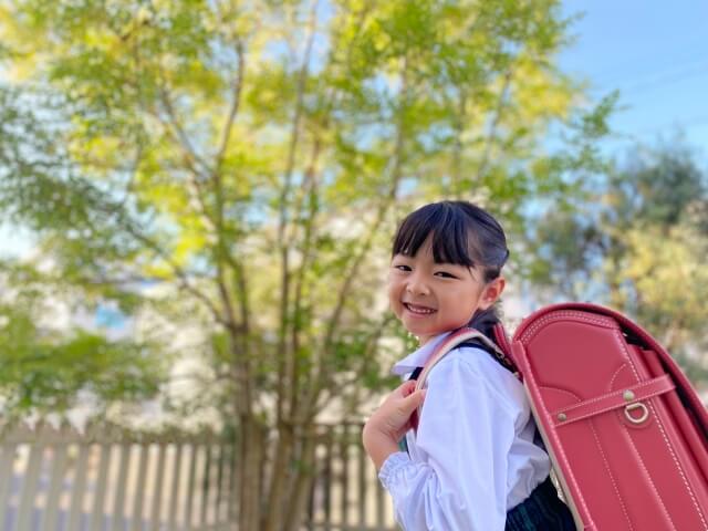 プレゼントのランドセルを背負って写真を撮っている女の子