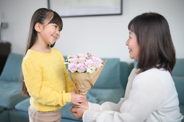 祖母の誕生日にお花を渡す孫