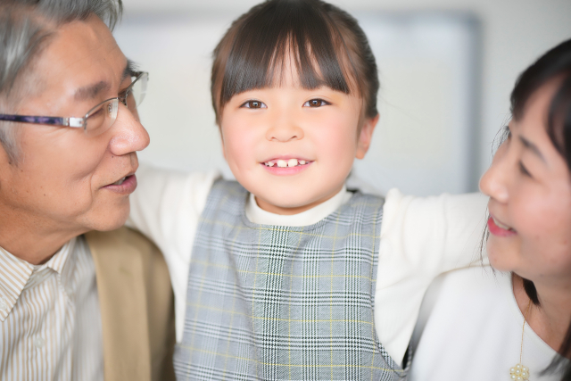 祖父母と笑顔で会話する孫娘